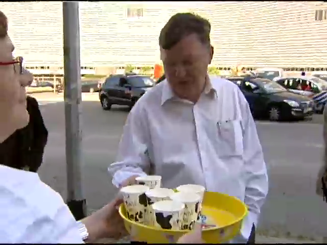 granjero repartiendo vasos de leche a la puerta del parlamento Europeo