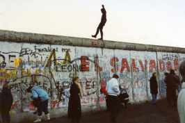 un hombre baila sobre el muro de Berlín