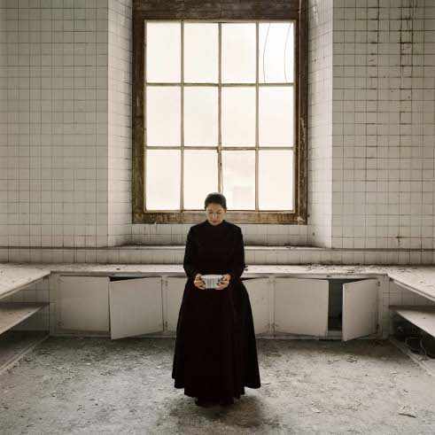 mujer en el centro de una cocina antigua vacía