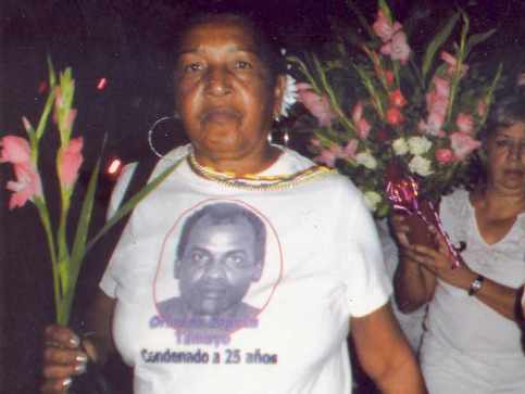 Reina Tamayo con unas flores en la mano y una camiseta con la foto de su hijo