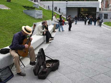 un músico toca la guitarra delante del Museo del prado