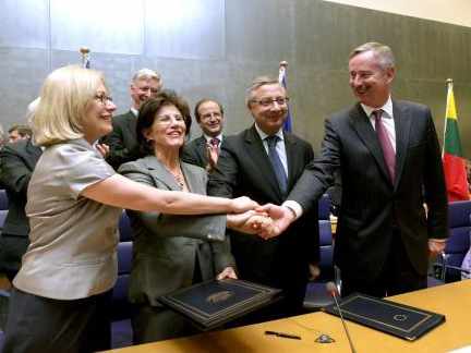 Los firmantes del pacto juntan sus manos felicitándose