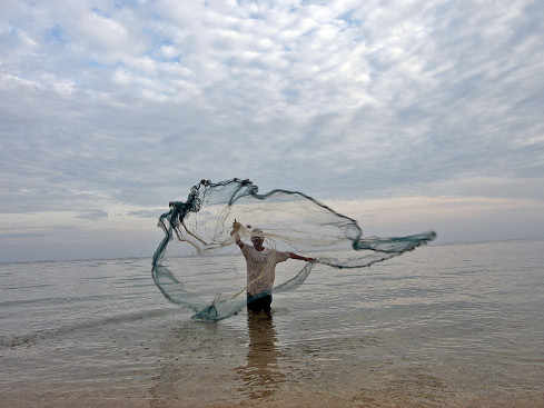 Un pescador echa una red