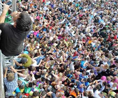 chicos subiendo por unas columnas metálicas, abajo una multitud intenta hacer lo mismo