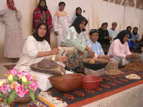 mujeres sentadas en el suelo fabricando aceite de argán