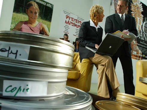 latas de películas y dos personas hablando al fondo