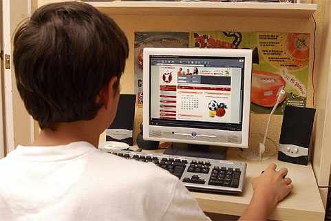 un niño de espaldas ante la pantalla de un ordenador