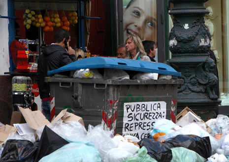 gran cantidad de bolsas de basura tiradas delante de una frutería