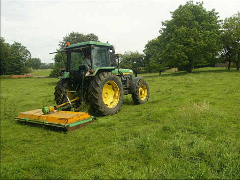 Un tractor en medio de un campo muy verde