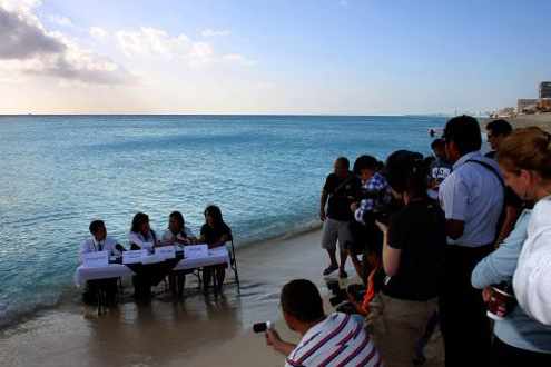 Una mesa con cuatro intervinientes en la orilla del mar