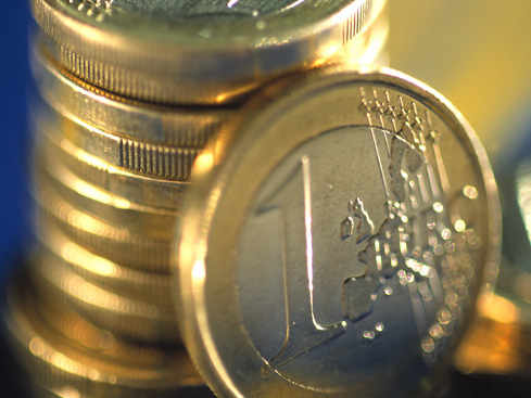 una torre de monedas y 1 euro apoyado en ella