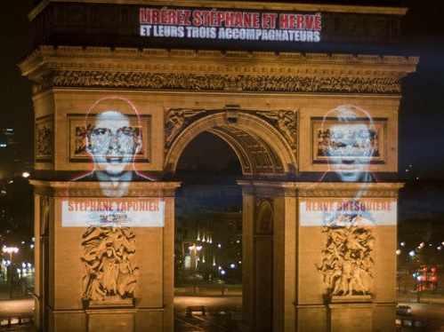 sobre el Arco de Triunfo de París las imágenes de los dos reporteros secuestrados