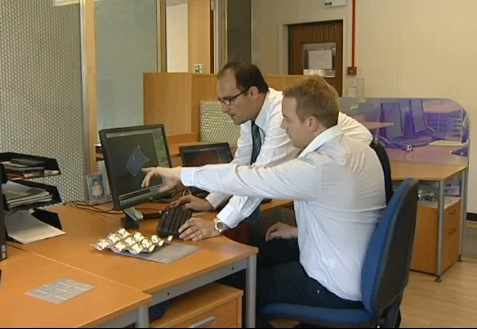 Dos hombres de mediana edad trabajando en el ordenador