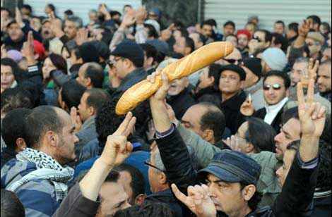 numerosos manifestantes, uno e ellos con una barra de pan en la mano