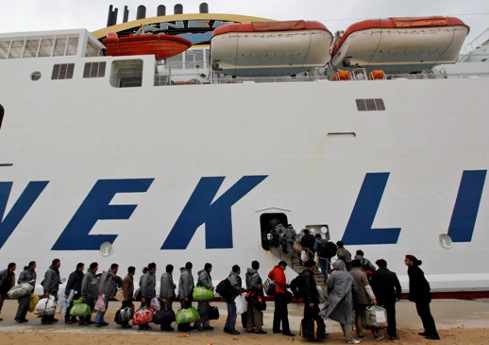 una larga fila de personas subiendo a un barco