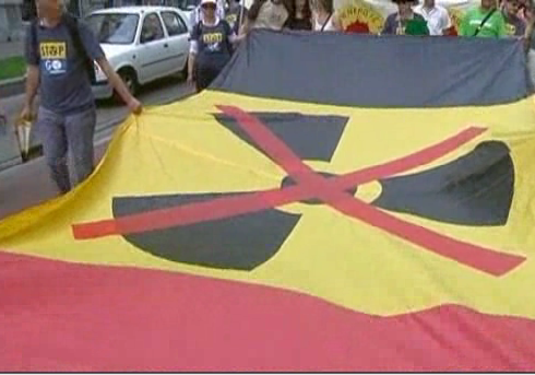 manifestantes llevan una bandera con el símbolo nuclear tachado