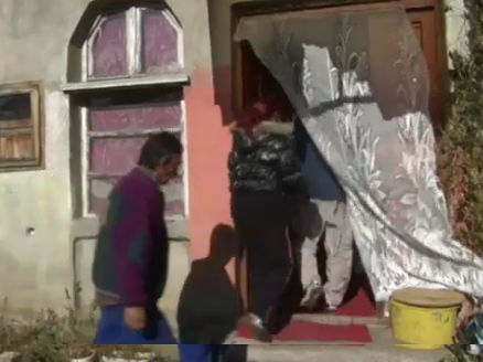 una familia entrando en una casa con una cortina de tela en la puerta