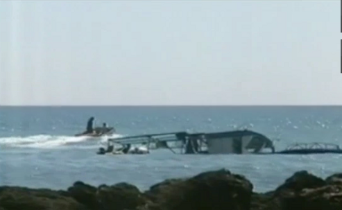 Un barco hundido al lado de unas rocas