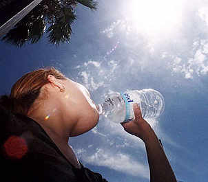 Una joven bebe agua al sol