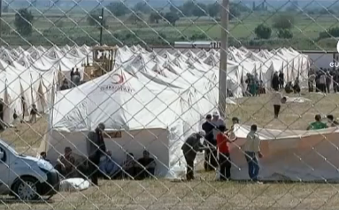 Unos hombres instalan tiendas de campaña en un campamento de refugiados