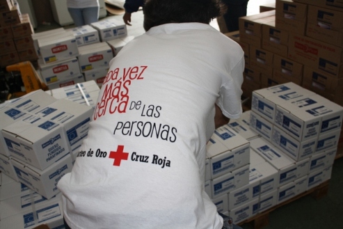 Cajas de alimentos y un operario con una bata del reparto de alimentos